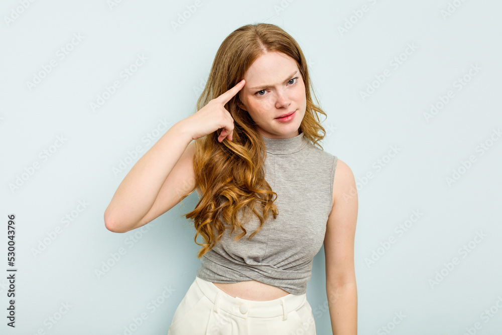 Young caucasian woman isolated on blue background pointing temple with finger, thinking, focused on a task.