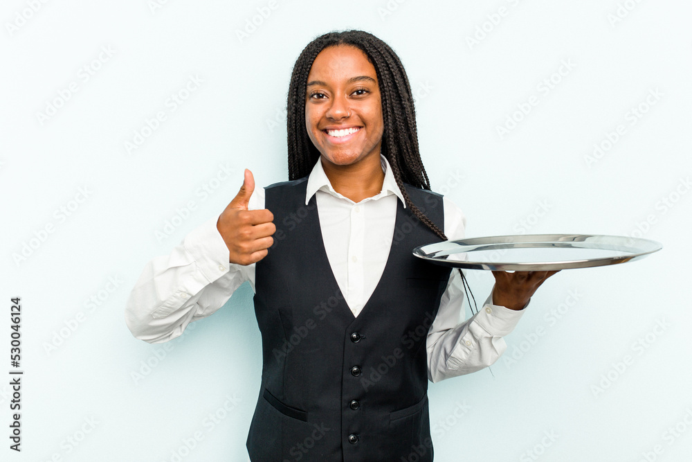 Young African American waitress woman holding a tray isolated on blue background smiling and raising thumb up