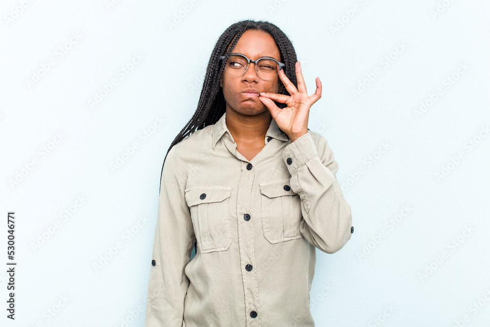 Young African American woman with braids hair isolated on blue background with fingers on lips keeping a secret. Young African American woman with braids hair isolated on blue background with fingers on lips keeping a secret.