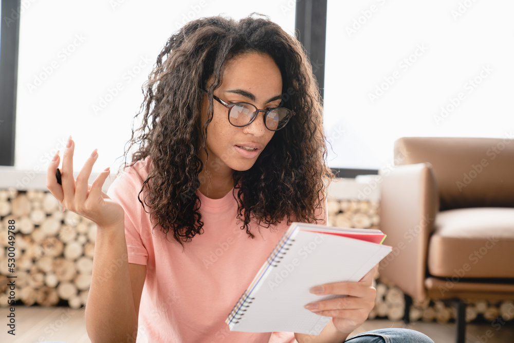 Young african businesswoman student freelancer tutor writing, doing paperwork, to-do list, preparing for test exam, doing homework for college university Young african businesswoman student freelancer tutor writing, doing paperwork, to-do list, preparing for test exam, doing homework for college university