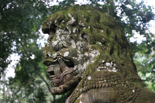 Old Indonesian Temple Statue in Lush Tropical Forest on the island of Bali, Indonesia © Nate Hovee