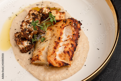 Canvas Print mashed fish, fried fish on a black background side view