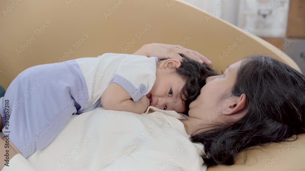 Healthy asian mother embrace newborn baby in living room, mom holding toddler on brown sofa with fun and tender. Adorable little boy having fun with mum togerther at home.
Healthy asian mother embrace newborn baby in living room, mom holding toddler on brown sofa with fun and tender. Adorable little boy having fun with mum togerther at home.