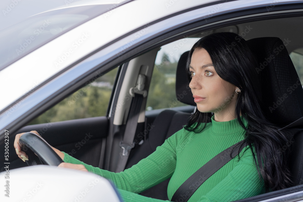 A serious young woman drive in her car. driver steering car with safety belt. Car Transportation concept. A serious young woman drive in her car. driver steering car with safety belt. Car Transportation concept.