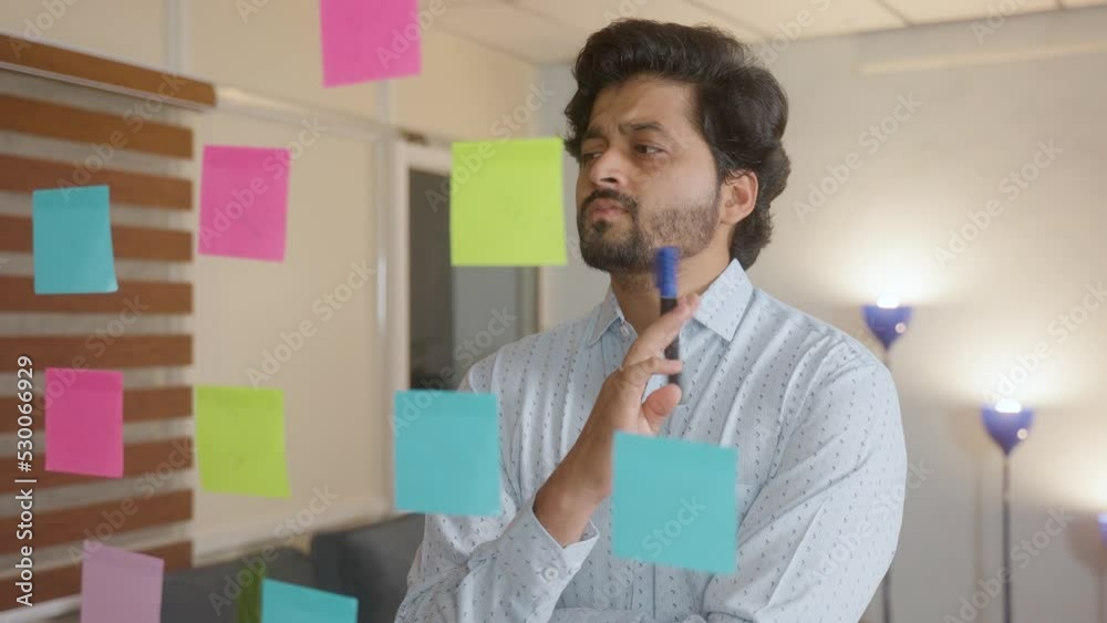 thoughtful Entrepreneur or employee busy planning by wiriting on sticky notes at office - concept of brainstorming, expertise and development thoughtful Entrepreneur or employee busy planning by wiriting on sticky notes at office - concept of brainstorming, expertise and development