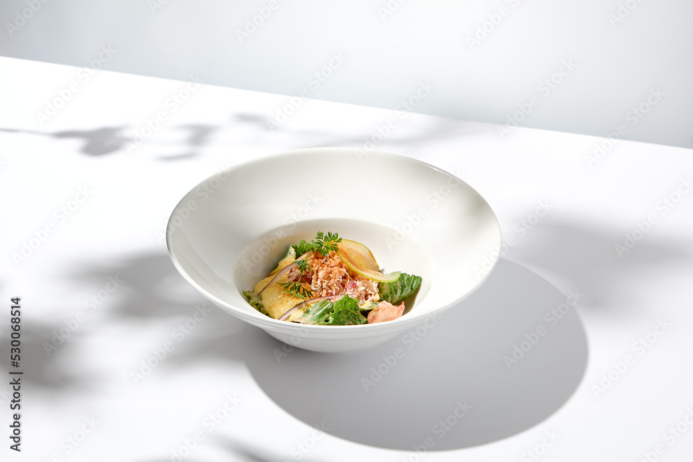 Elegant salad with crab meat, espuma sauce and lettuce on white table with harsh shadows. Green salad with crab and creamy sauce in summer menu. Aesthetic food. Seafood appetizer. Elegant salad with crab meat, espuma sauce and lettuce on white table with harsh shadows. Green salad with crab and creamy sauce in summer menu. Aesthetic food. Seafood appetizer.
