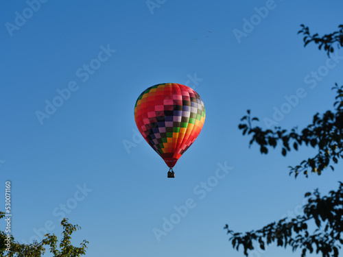 Colorful hot air balloon flying through the blue sky