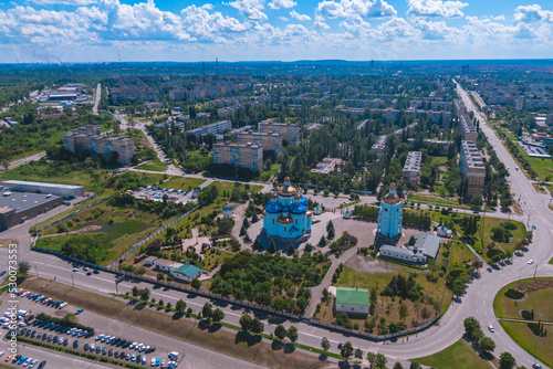 Fototapeta Naklejka Na Ścianę i Meble -  Spaso-Preobrazhensky Cathedral against the blue sky. Ukraine, Krivoy Rog. Aerial view from a drone. Urban landscape. City center panorama