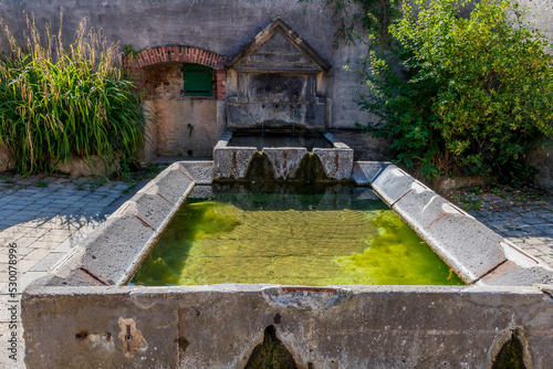 Ancien lavoir datant de Napoléon 1er servant actuellement de fontaine avec son eau claire dans un petit village du puy de dôme photo