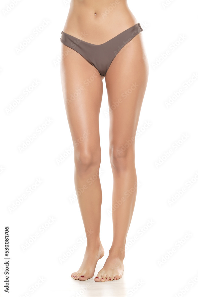 Female legs in black bikini panties ona white background