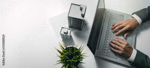 real estate business and development, property management. businessman using laptop and working on housing project in office. banner with copy space