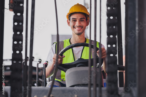 Young Asian work man driving the truck over construction site. Industrial factory worker operating on forklift in the import export shipyard. Foreman at warehouse logistic in Cargo freight ship.