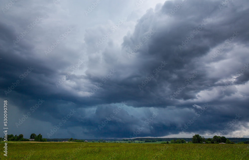 Storm clouds over field, tornadic supercell, extreme weather, dangerous storm Storm clouds over field, tornadic supercell, extreme weather, dangerous storm