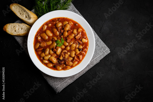 Tasty polish white baked beans and sausage in tomato sauce