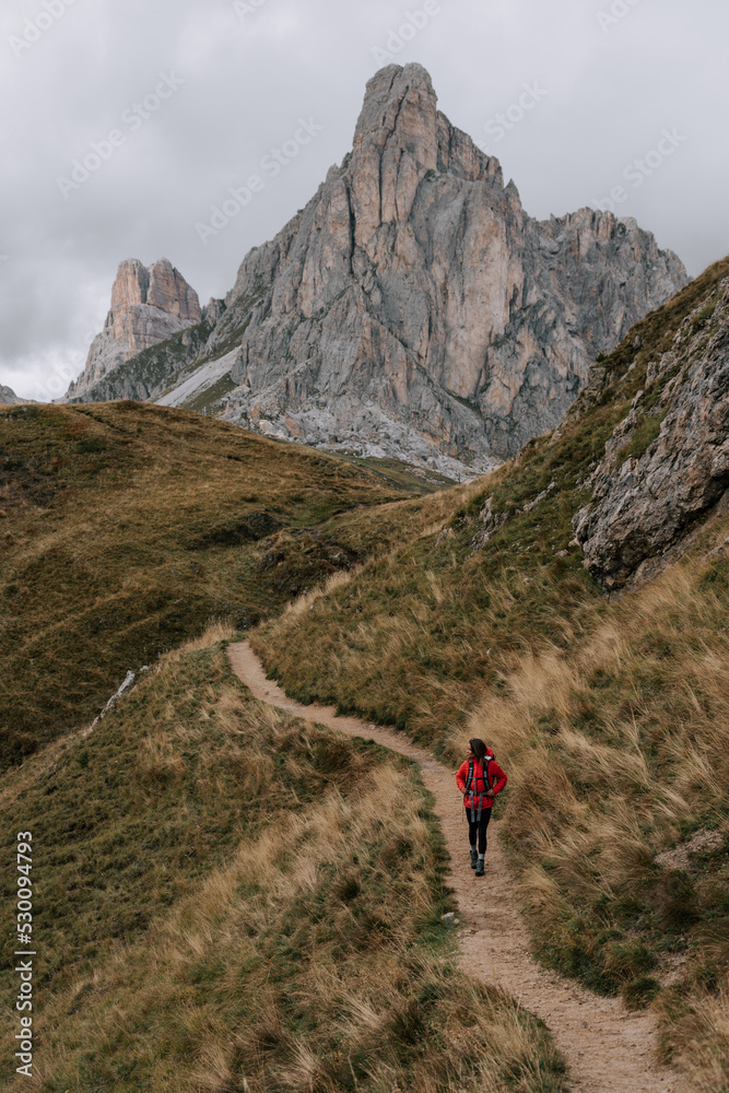 Eine Frau wandert am Passo Giau in den Dolomiten. Wechselhaftes Wetter in den Dolomiten 1