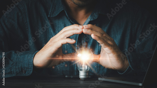 Fotografía Light blub under hands, businessman protects the light bulb, Creative new idea,