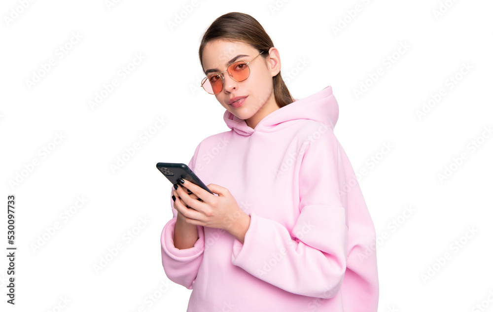 Modern millennial girl in casual pink hoodie and glasses using smartphone isolated on white, gen Y Modern millennial girl in casual pink hoodie and glasses using smartphone isolated on white, gen Y