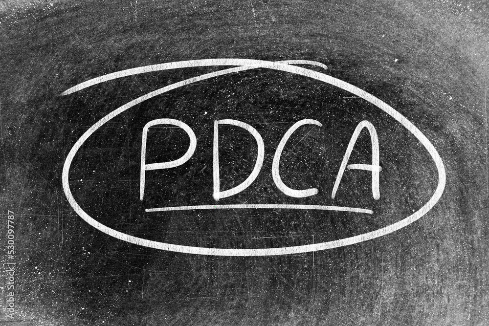 White chalk hand writing in word PDCA (Abbreviation of plan do check act) on blackboard background White chalk hand writing in word PDCA (Abbreviation of plan do check act) on blackboard background