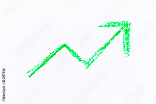 Green color oil pastel hand drawing in upward trend arrow shape on white paper background