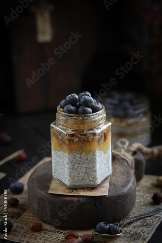 Chia pudding with nuts and blueberries on a wooden board