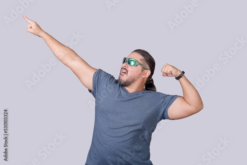 Foto An exuberant and wild man poses pointing up while flexing his arms