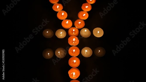 Japanese Yen Symbol Made of Burning Votive Candles Black Background photo