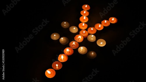 Japanese Yen Symbol Made of Burning Votive Candles Black Background photo