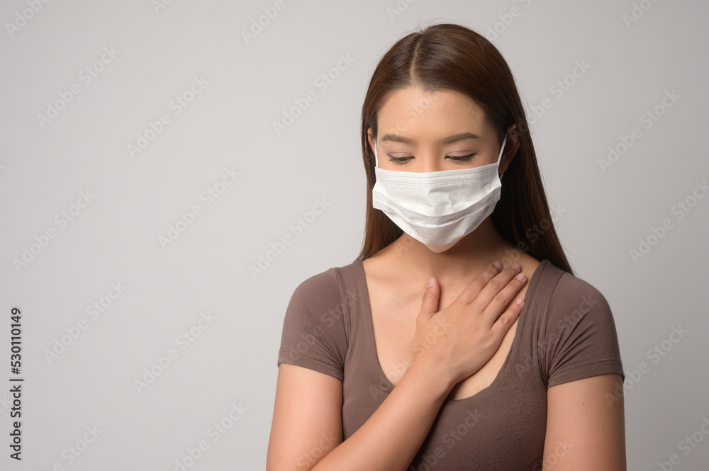 Young asian woman wearing protective mask over white background studio, safety travel , new normal , social distancing , covid19 and pandemic concept.