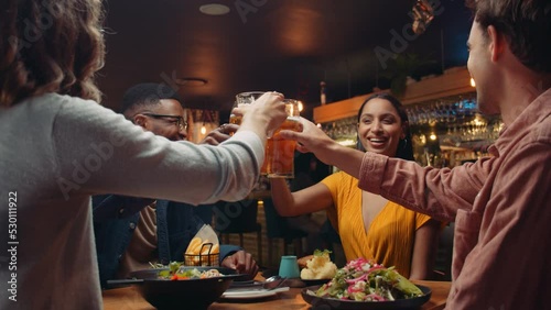 Diverse group of friends out for dinner making a toast