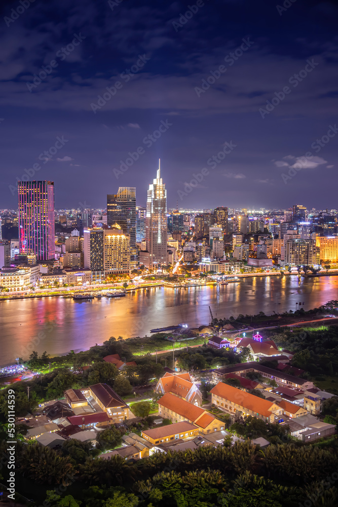 Obraz premium Aerial view view of Ho Chi Minh City skyline and the Saigon River at sunset. Amazing colorful view of skyscraper and other modern buildings at downtown.
