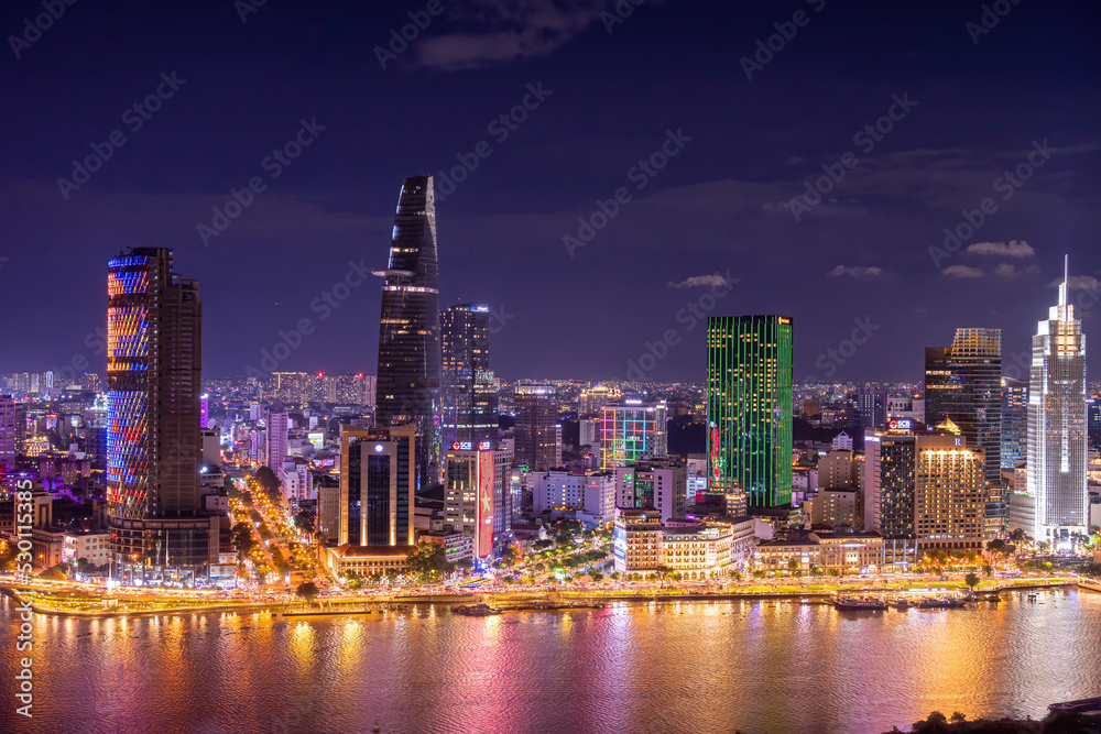 Obraz premium Aerial view of Bitexco Tower, buildings, roads, Thu Thiem 2 bridge and Saigon river in Ho Chi Minh city - Far away is Landmark 81 skyscraper. Travel concept.