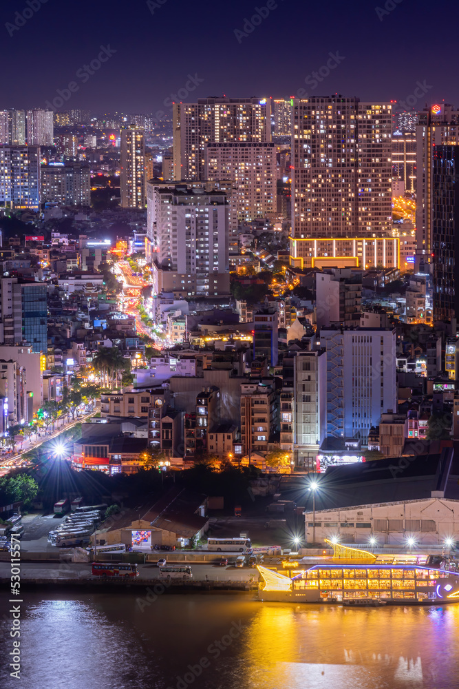 Naklejka premium Aerial view of Bitexco Tower, buildings, roads, Thu Thiem 2 bridge and Saigon river in Ho Chi Minh city - Far away is Landmark 81 skyscraper. Travel concept.