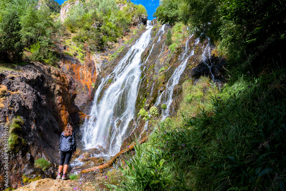 Joven montañera disfrutando de la cascada de Espigantosa, en el Valle de Eriste, en el pirineo argonés, en Huesca.