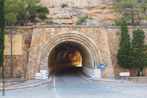road to a tunnel with a luminous exit