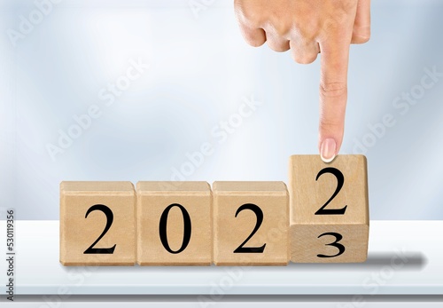 New year concept. Human hand touch wooden cube.
