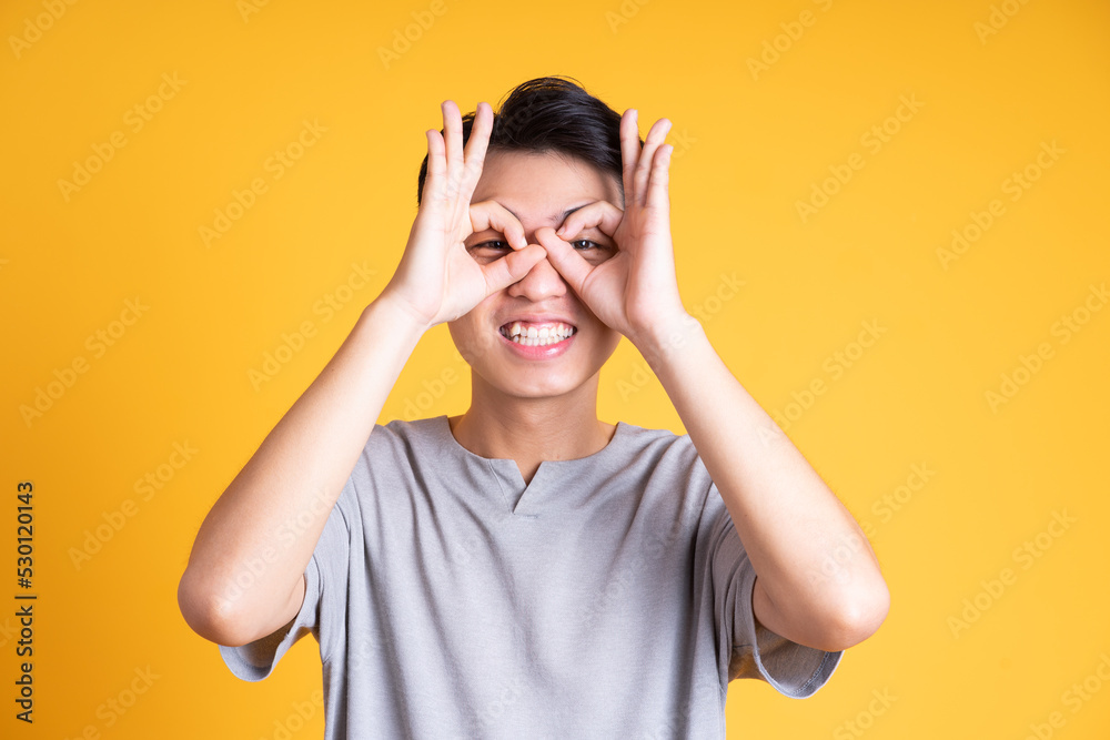 Asian young man posing on a yellow background Asian young man posing on a yellow background