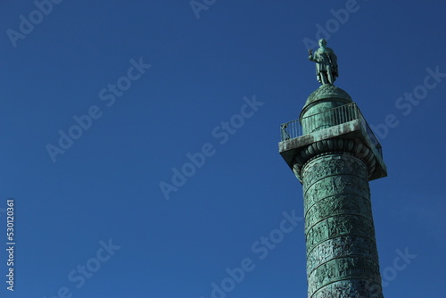 Top of Vendôme Column including Napoleon statue against a clear blue sky. A French landmark in the 1st arrondissement of Paris