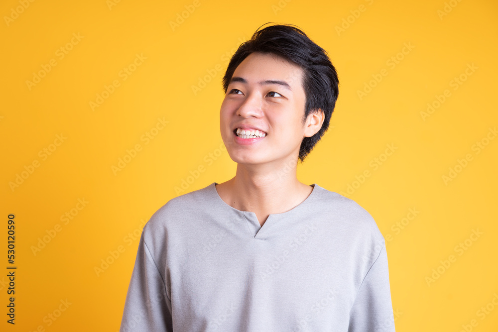 Asian young man posing on a yellow background Asian young man posing on a yellow background