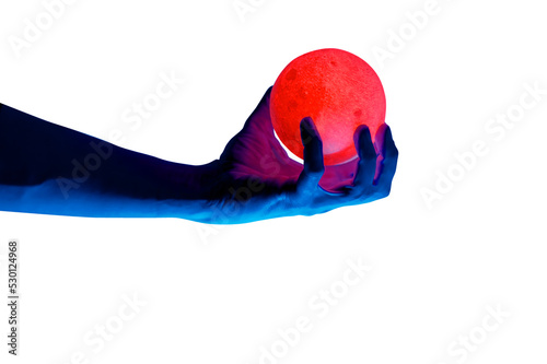 Human migician hand holding red illuminated sphere. Surrealistic collage element, contemporary art for design, posters and banners. Neon purple light. Pop fantasy style