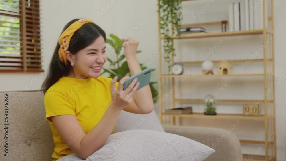 Young beautiful woman plays games on smartphone with happy to win. Young beautiful woman plays games on smartphone with happy to win.