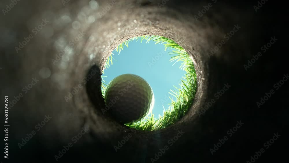 Super slow motion of falling golf ball into hole. Unique perspective angle of view. Filmed on high speed cinema camera, 1000fps.
