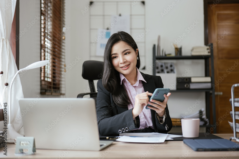 Young business women working on laptop with happy and smile face on office spec. Young business women working on laptop with happy and smile face on office spec.