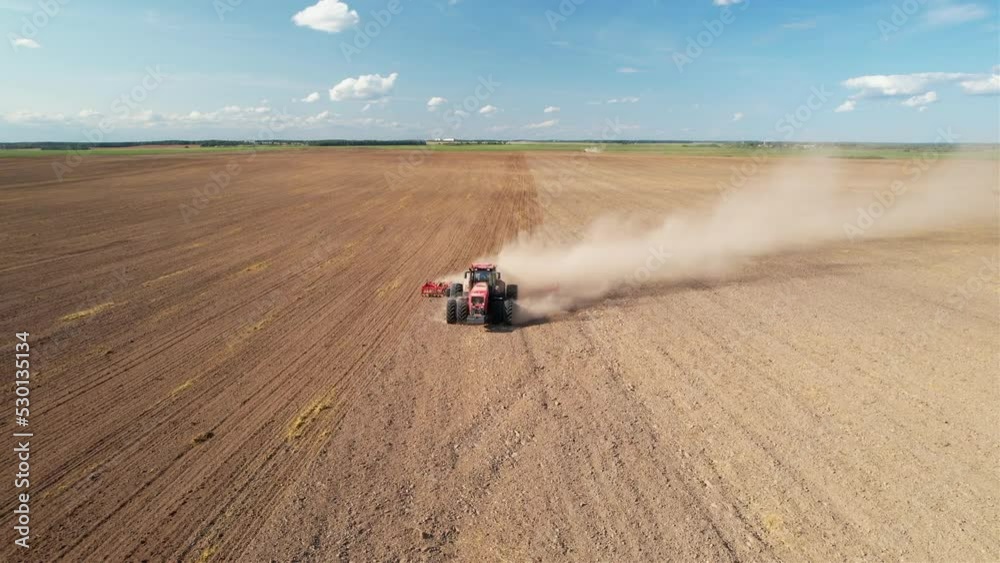 Tractor with disc cultivator on field cultivating. Disk harrow on