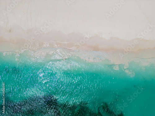 Empty Tropical Beach with shore line from above showing blue tropical waters and sandy beach.. High quality photo