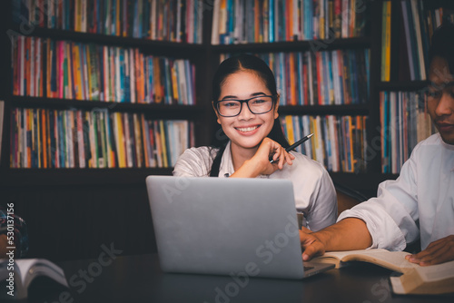 Group of Diversity Student talking and laughing together at asian college, working on laptop and smart phone. Happy multi ethnic friend successfully completes the thesis report and passed final exam
