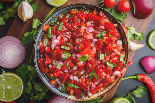 Top view of fresh salsa made with homegrown ingredients of tomatoes, red onions, garlic, chili peppers, cilantro and lime