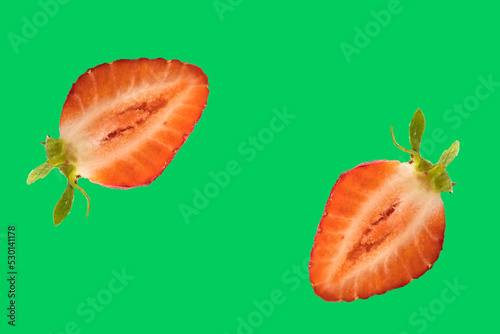 Strawberry fruit with strawberry leaf isolated on green background.
