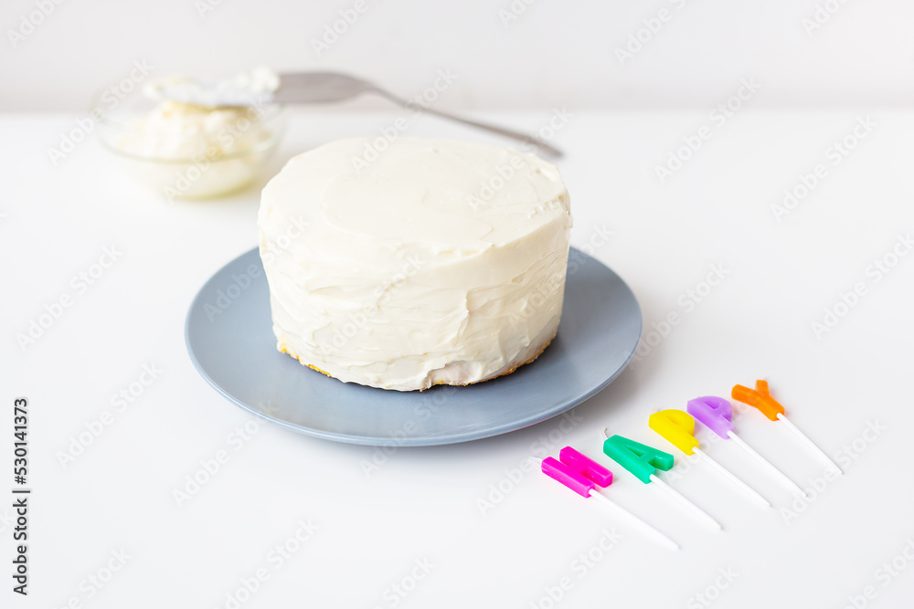 Preparing for a birthday cake, the inscription happiness on a creamy cookie. Surprise holiday and birthday concept.
