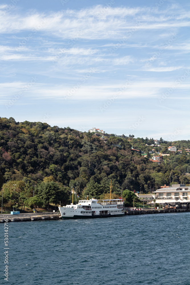 View of moored ferry boat on Bosphorus in Kurucesme area of European side of Istanbul. It is a sunny summer day. Beautiful travel scene.