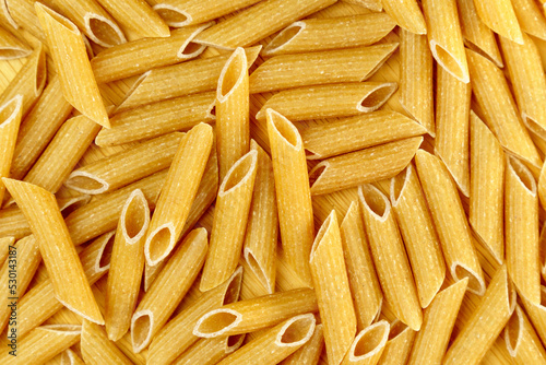 Whole grain penne pasta from durum wheat. Top view. Texture